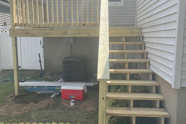 A wooden deck featuring stairs and a ladder leading to the outdoor area, providing access and enhancing outdoor living space.